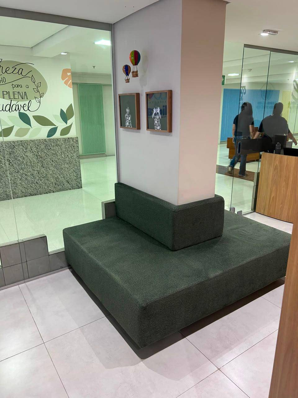 Sala de espera do consultório no Plaza Avenida Shopping com sofá verde e decoração infantil
